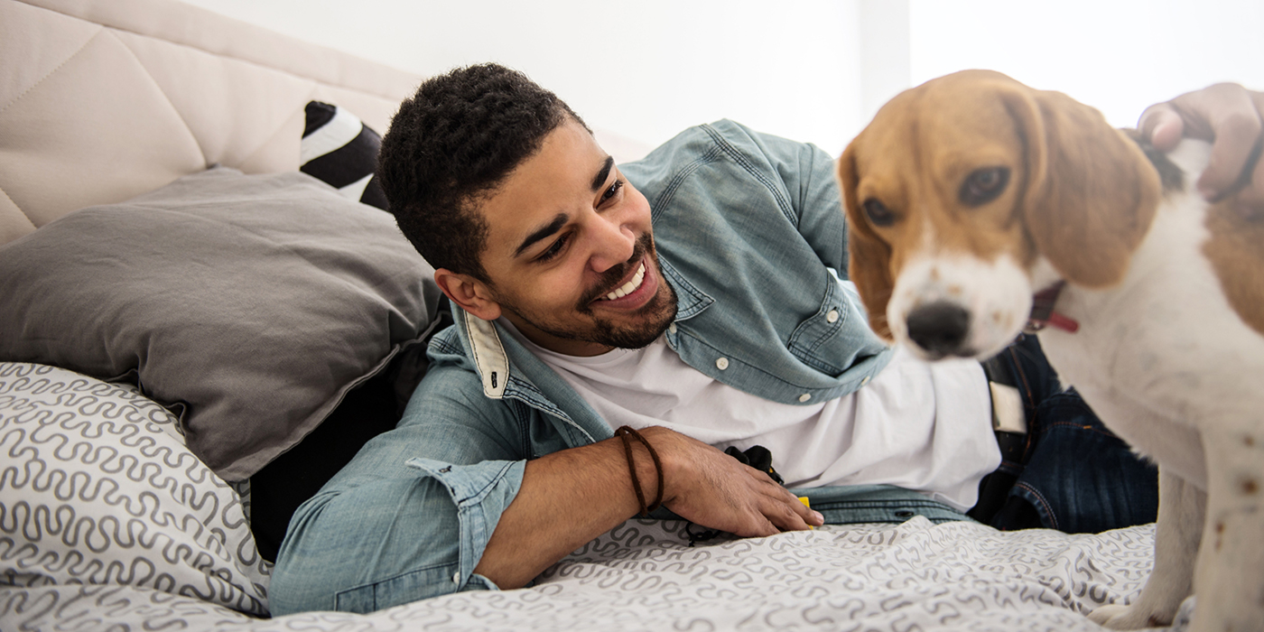 man and dog on the bed