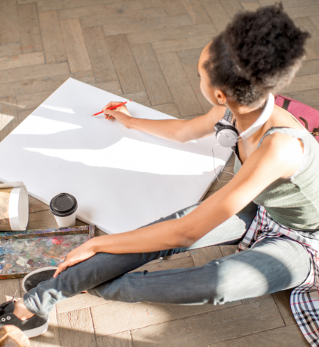 a femaile artist drawing on a large piece of paper